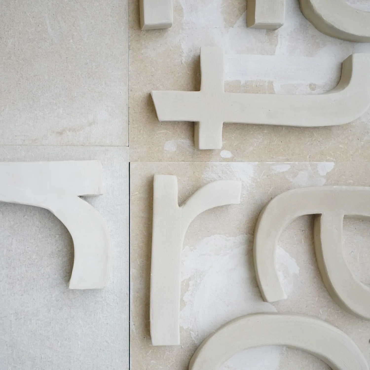 Handmade ceramic letters drying in the Lüt Studio workshop