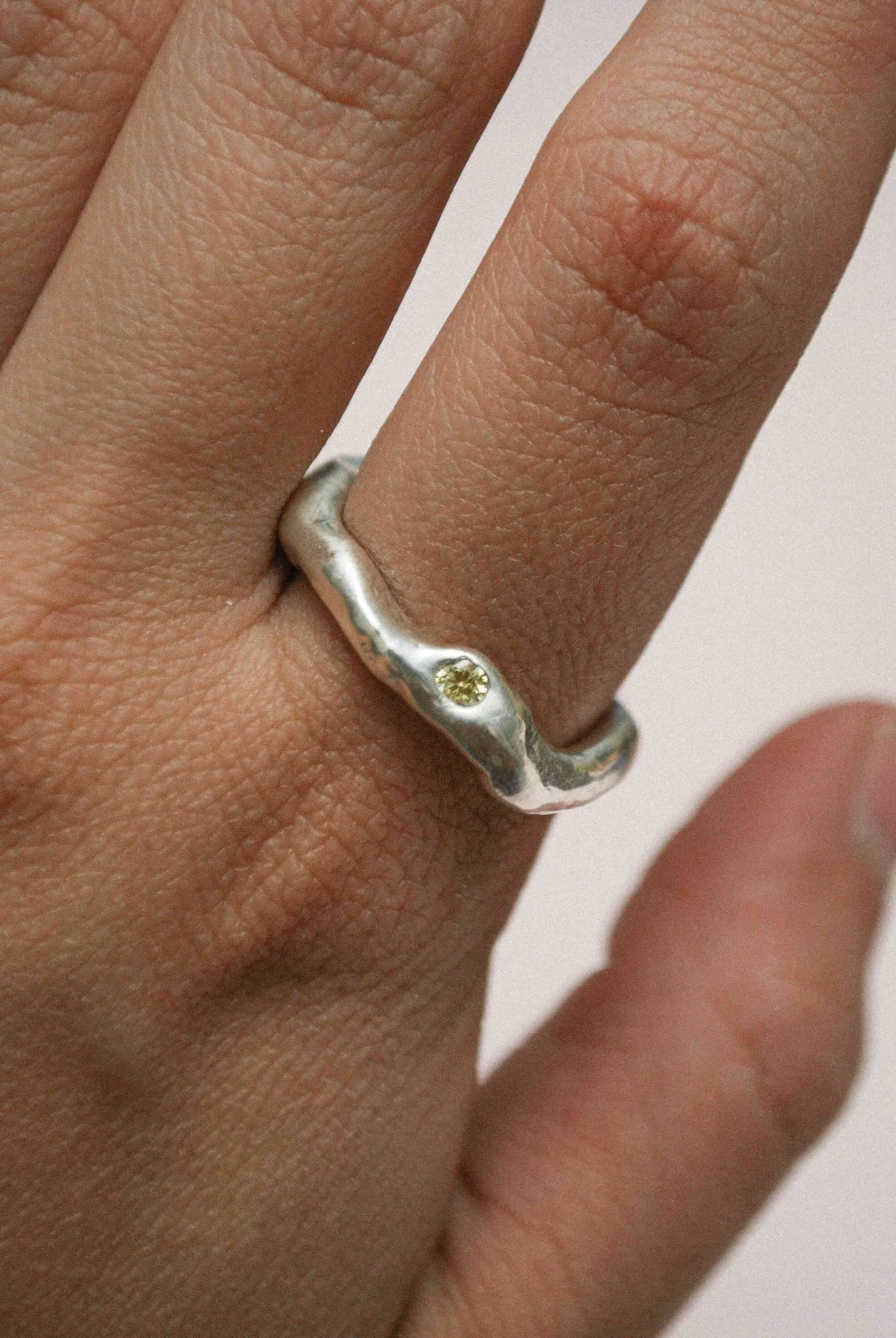 A finished silver ring with a softly textured band