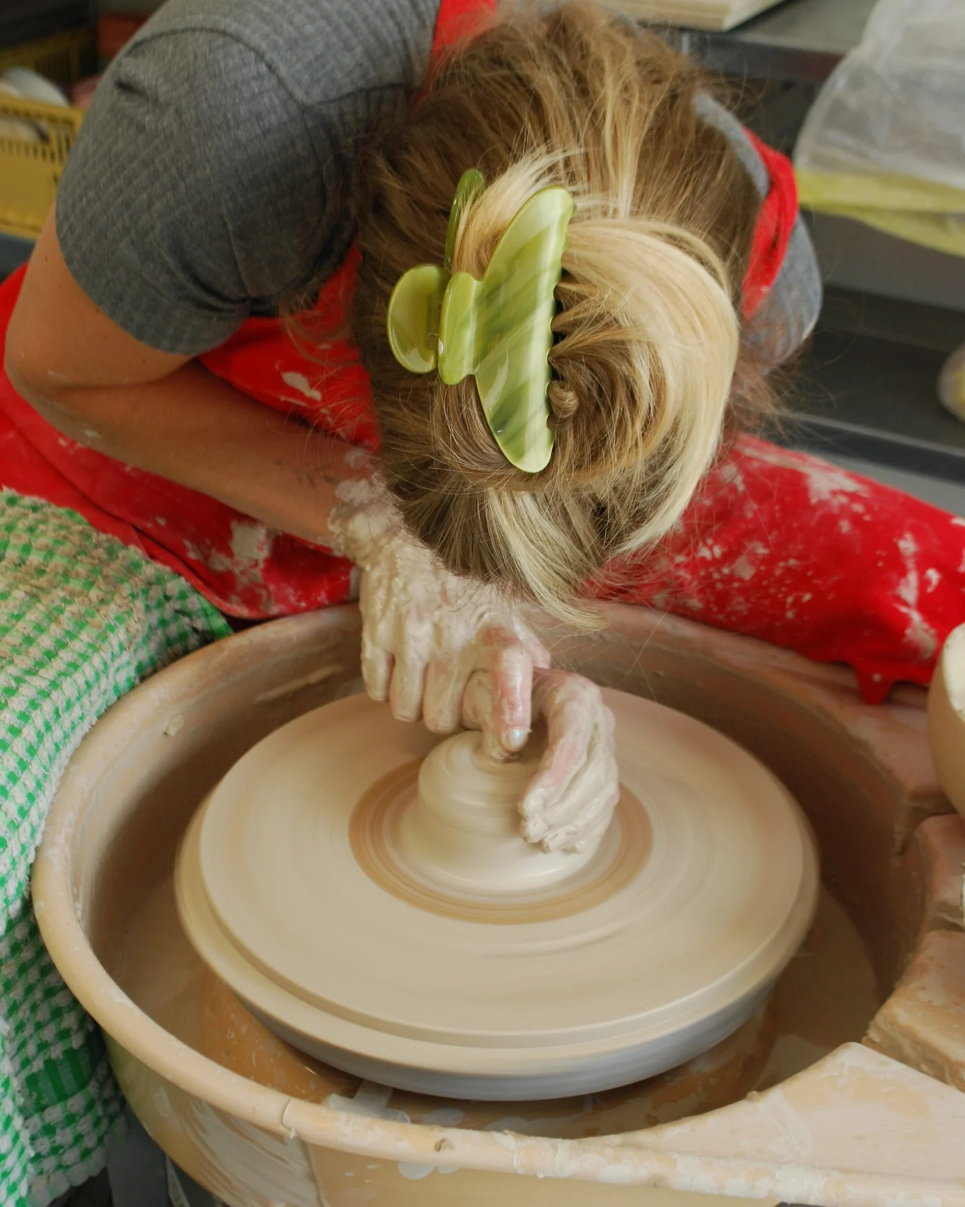 Overhead view of a potter centring clay on a spinning wheel